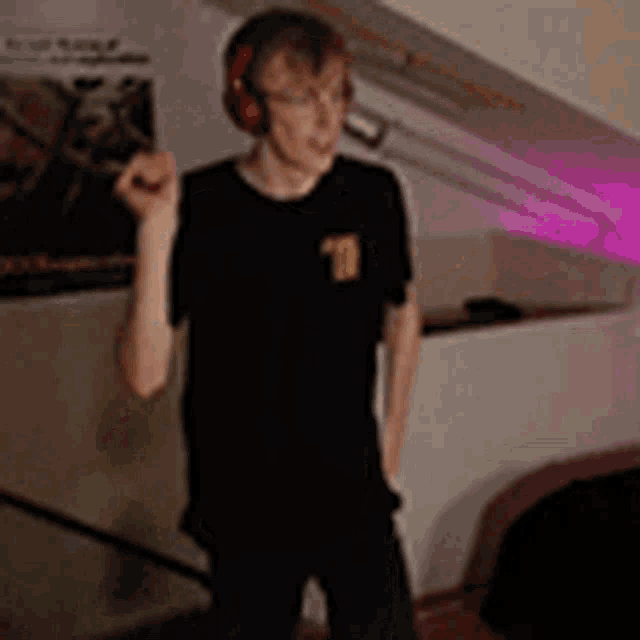 a young man wearing headphones is standing in a room .
