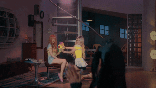 a woman is taking a picture of two girls in a room