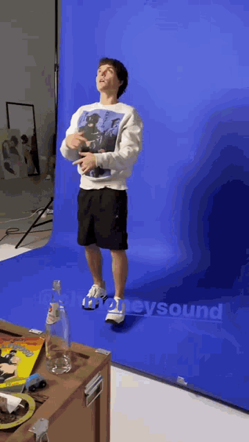 a man is standing in front of a blue backdrop with the word sound written on it