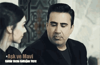 a man and a woman are looking at each other with the words ask ve mavi in the corner .
