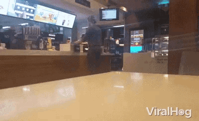 a man standing at a counter in a mcdonald 's with the word viralhog on the bottom