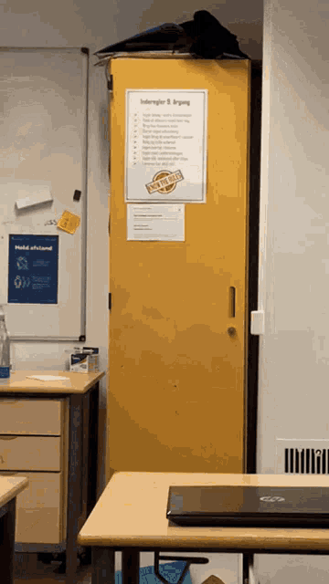 a classroom with a yellow door and a sign that says " no smoking "