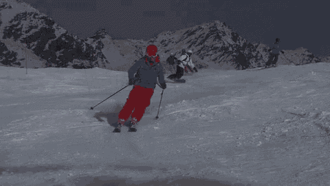 a group of skiers are skiing down a snow covered mountain .