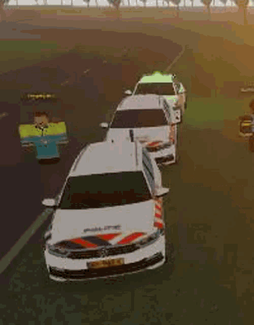 a bunch of police cars are driving down a road .