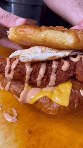a close up of a sandwich with cheese and a fried egg