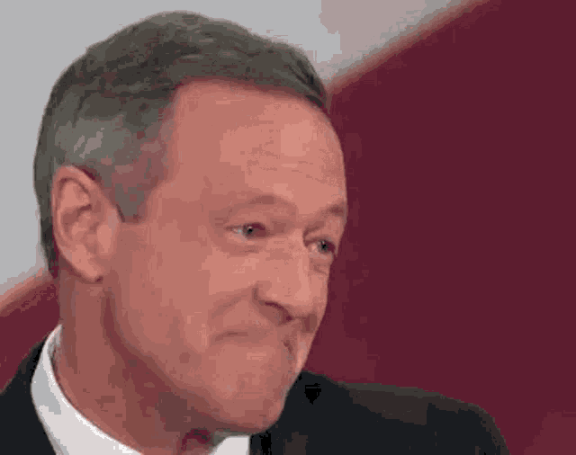a man in a suit and tie is making a funny face with his mouth open .