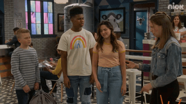 a group of kids are standing in a room with a sign that says nick on it