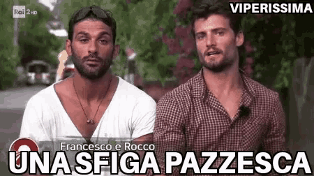 two men are standing next to each other in front of a sign that says francesco e rocco una sfida pazzesca .