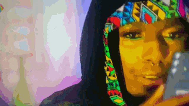a pixelated image of a woman wearing a colorful hat and a hoodie