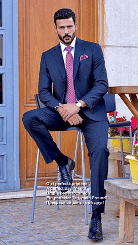 a man in a suit and tie sits on a chair