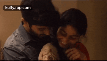 a man and woman are hugging each other in a room .