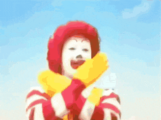 a mcdonald 's clown is holding his arms in the air