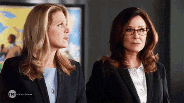two women standing next to each other with a tnt logo in the corner