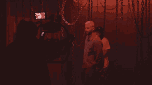 a man stands in front of a camera in a dark room