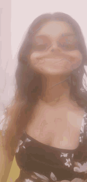 a woman wearing sunglasses and a black top is smiling for the camera