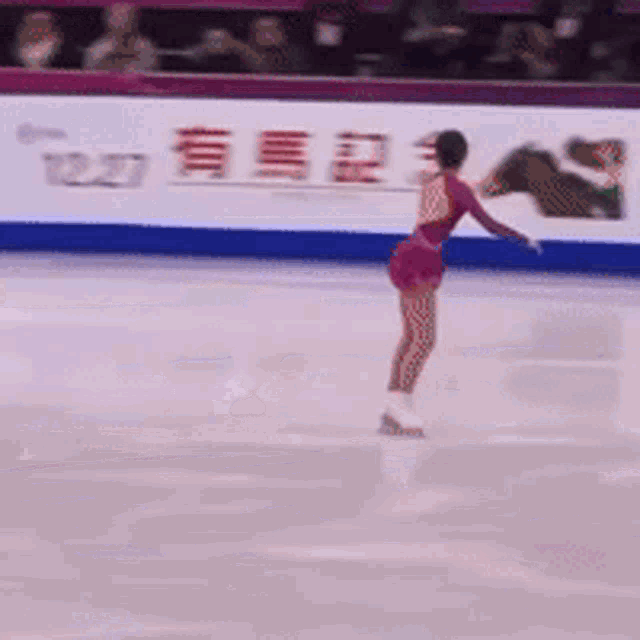 a woman is skating on a rink with a canon sign in the background
