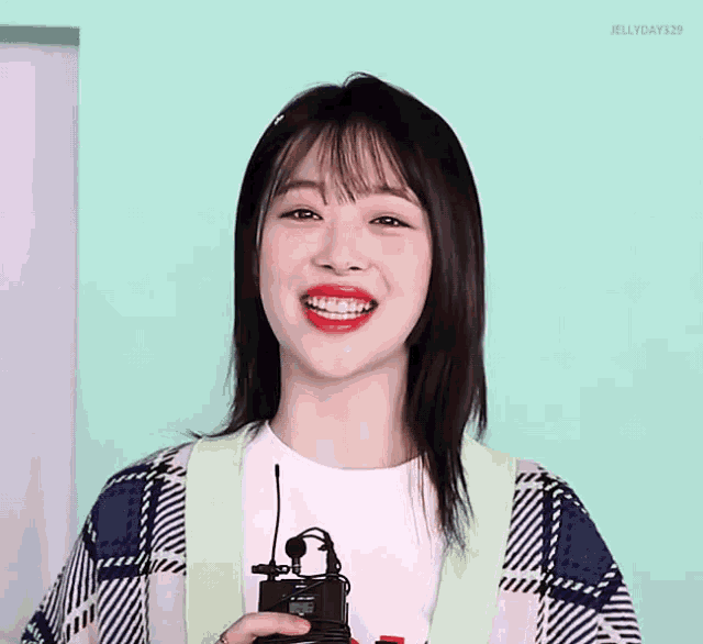 a woman with red lipstick is smiling and holding a microphone with jellyday328 written below her