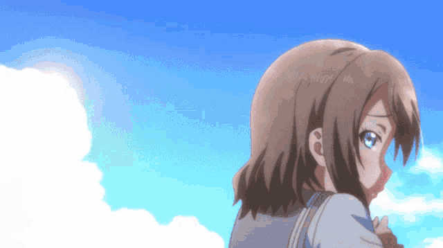 a girl with brown hair and blue eyes stands in front of a blue sky with white clouds
