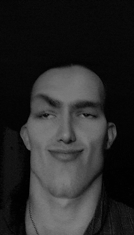a black and white photo of a man making a face .