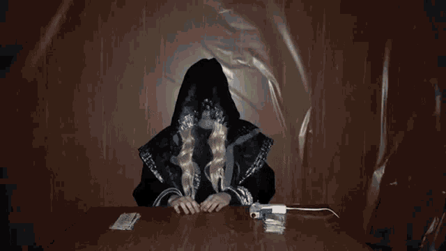 a woman sitting at a table with a stack of playing cards