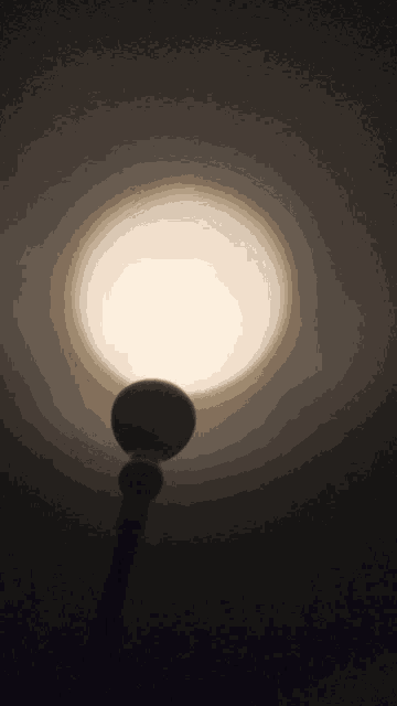 a light is shining in the dark and a silhouette of a person is visible