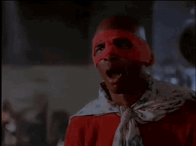 a man with a red mask on his face screams