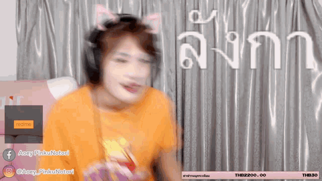 a blurry picture of a girl wearing headphones and a shirt that says aacy pinku notori
