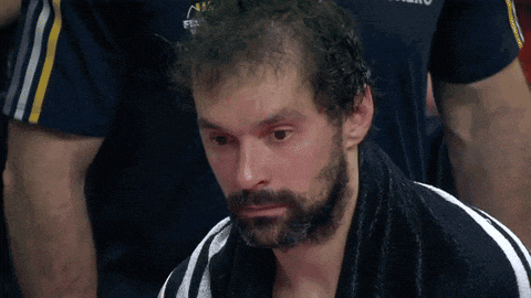 a man with a beard and a towel around his neck looks down