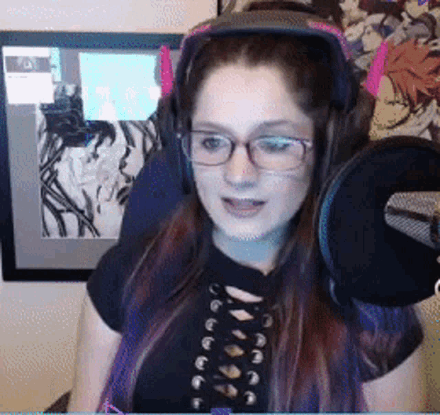 a woman wearing headphones and glasses is speaking into a microphone