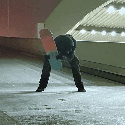 a person holding a snowboard that has a red and blue stripe