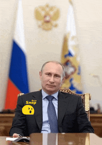 a man wearing a suit and tie with a snap sticker on his shirt