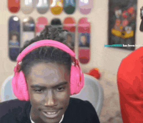 a man wearing pink headphones is looking at the camera