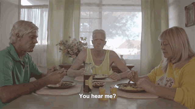 a group of people sitting at a table with the words " you hear me " in the corner