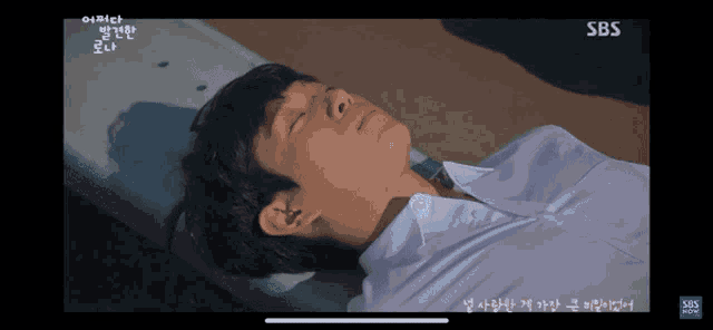 a man laying on a green bench with sbs written on the bottom of the screen