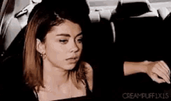 a woman is sitting in the back seat of a car looking out a window .