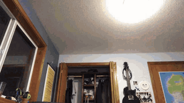 a room with a guitar and a map on the wall that says hawaii