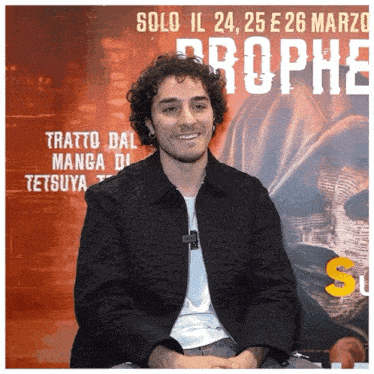 a man sits in front of a sign that says solo il 24 25 e 26 marzo