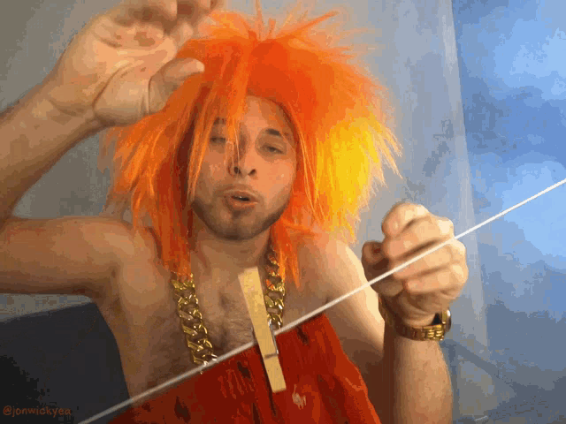 a shirtless man with orange hair is holding a clothespin