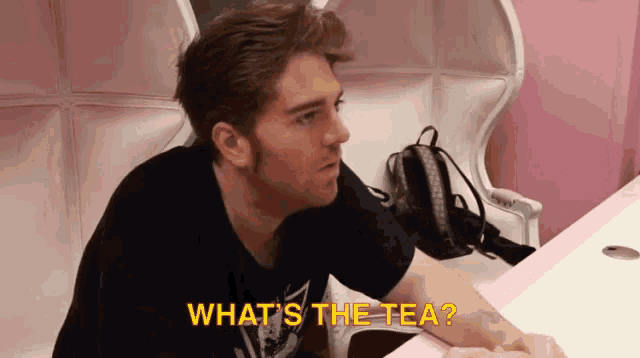 a man sitting at a table with the words what 's the tea