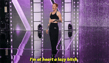 a woman is standing on a stage with purple lights and says i 'm at heart a lazy bitch .