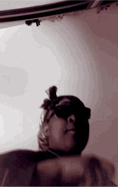 a blurry picture of a woman wearing sunglasses and a bandana