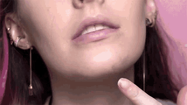 a close up of a woman 's face with a pink background .