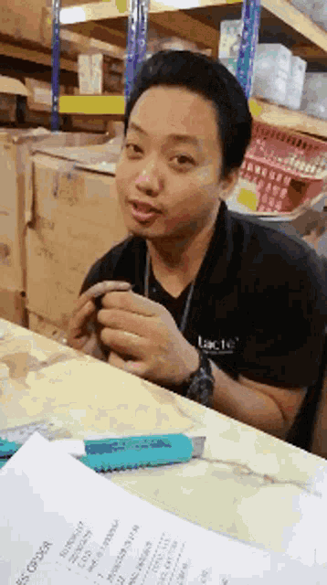 a man is sitting at a table with a knife and a piece of paper that says ' s order ' on it