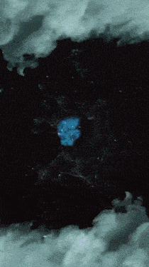 a dark background with a blue object in the middle of it