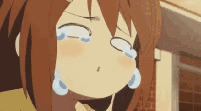 a girl with brown hair is crying with tears coming out of her eyes .