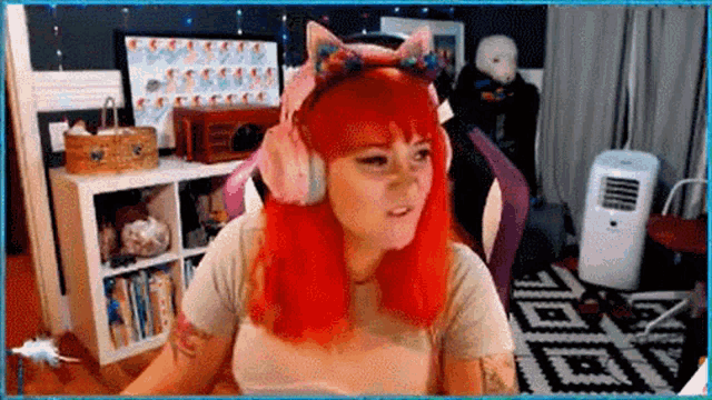 a woman with red hair is wearing cat ears and headphones while sitting in a chair in a living room .