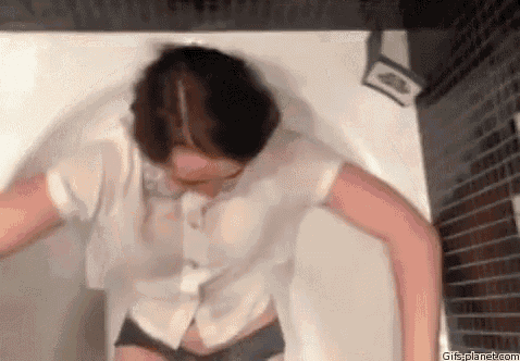 a woman is standing in a bathtub wearing a wet shirt and shorts .