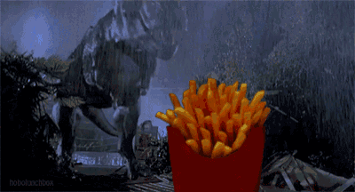 a t-rex is eating french fries from a red box