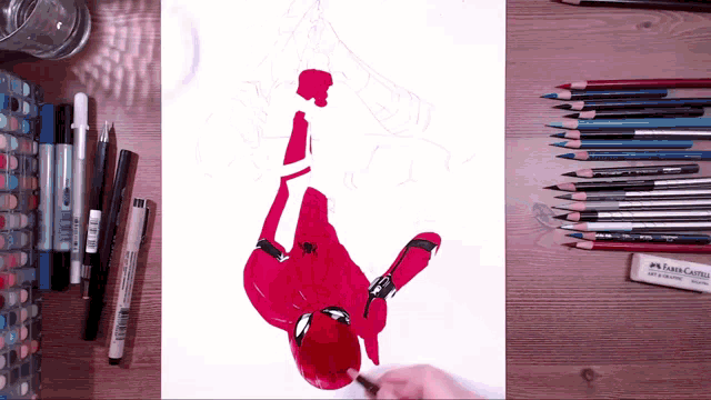 a person is drawing a spider man with a faber-castell eraser
