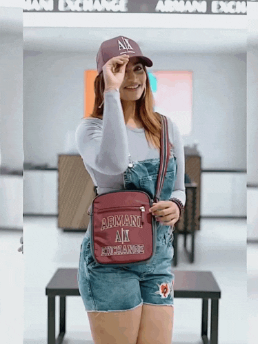 a woman wearing overalls and a armani exchange purse